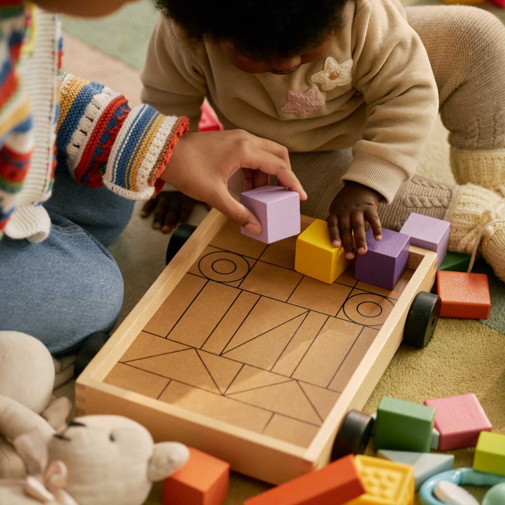 Children playing with a wooden toy